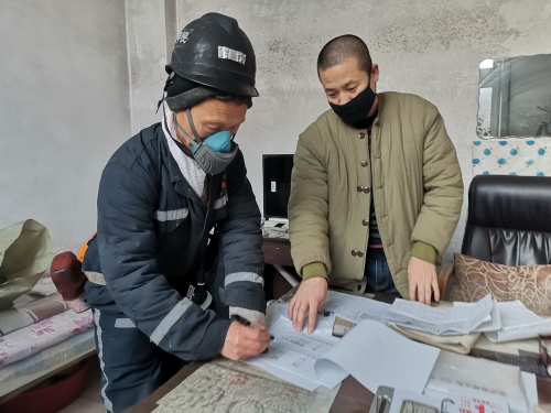 興安礦動力科排水隊井下水泵司機朱甲民（圖左）在安全確認本上簽字