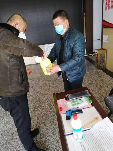 七臺河公司東風礦礦黨委副書記王占寒在督導檢查防疫工作的同時為單位提供測溫儀、消毒液、噴壺等防護用品。圖為王占寒（左）正與黨員對辦公場所進行消毒。（于秀娟攝）