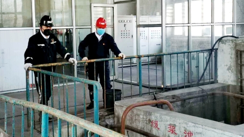 圖為鶴礦峻德煤礦在檢查緩漿池安全運行情況_副本