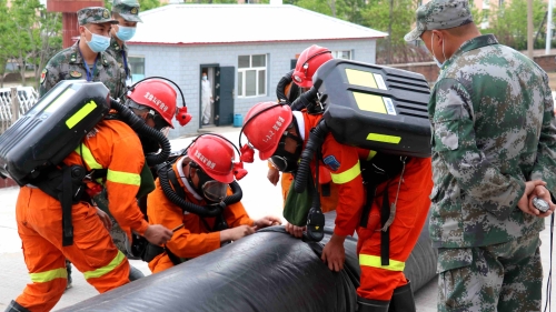 圖為：救護(hù)大隊(duì)技術(shù)比武演習(xí)安裝局部通風(fēng)機(jī)并接風(fēng)筒