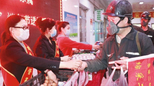圖為：東榮二礦女工將雞蛋和牛奶遞到職工手中，叮囑“安全第一”。